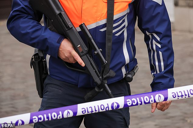 Fury mounted today when it was revealed that a headline on the BBC website described the shooting of two Swedish football supporters in Brussels last night as a 'terror attack'. Pictured: A Belgian police officer secures the area where the gunman is neutralised in Brussels