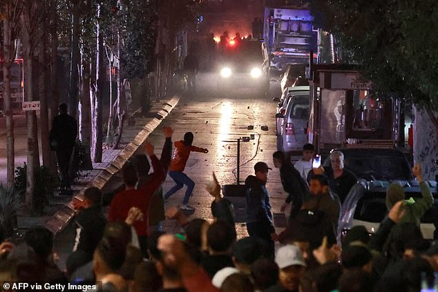 People clash with Palestinian security forces during a rally in solidarity with the Palestinians of the Gaza Strip in the West Bank city of Ramallah, on Tuesday