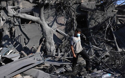 A youth walks on the rubble of a building following Israeli bombing in Rafah in the southern Gaza Strip