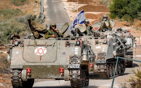 The Israeli army track medical vehicles moving along a road near the northern town of Kiryat Shmona 