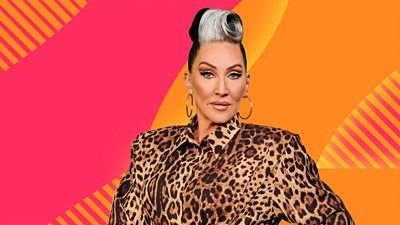 Headshot of Michelle Visage in front of orange and red branding. 