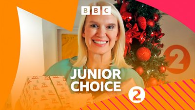 Photo of Anneka Rice smiling to camera holding presents, stood in front of a Christmas tree. BBC Radio 2 branding on the image reads: 