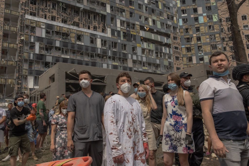 A Ukrainian doctor (C) stands amid the rubble of the destroyed building of the Okhmatdyt children's hospital after a Russian missile attack 