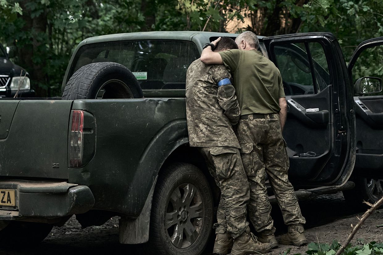 A Ukrainian soldier cries on his comrade's shoulder after returning from the Kursk region, on Aug.
/p
p14, 2024. 