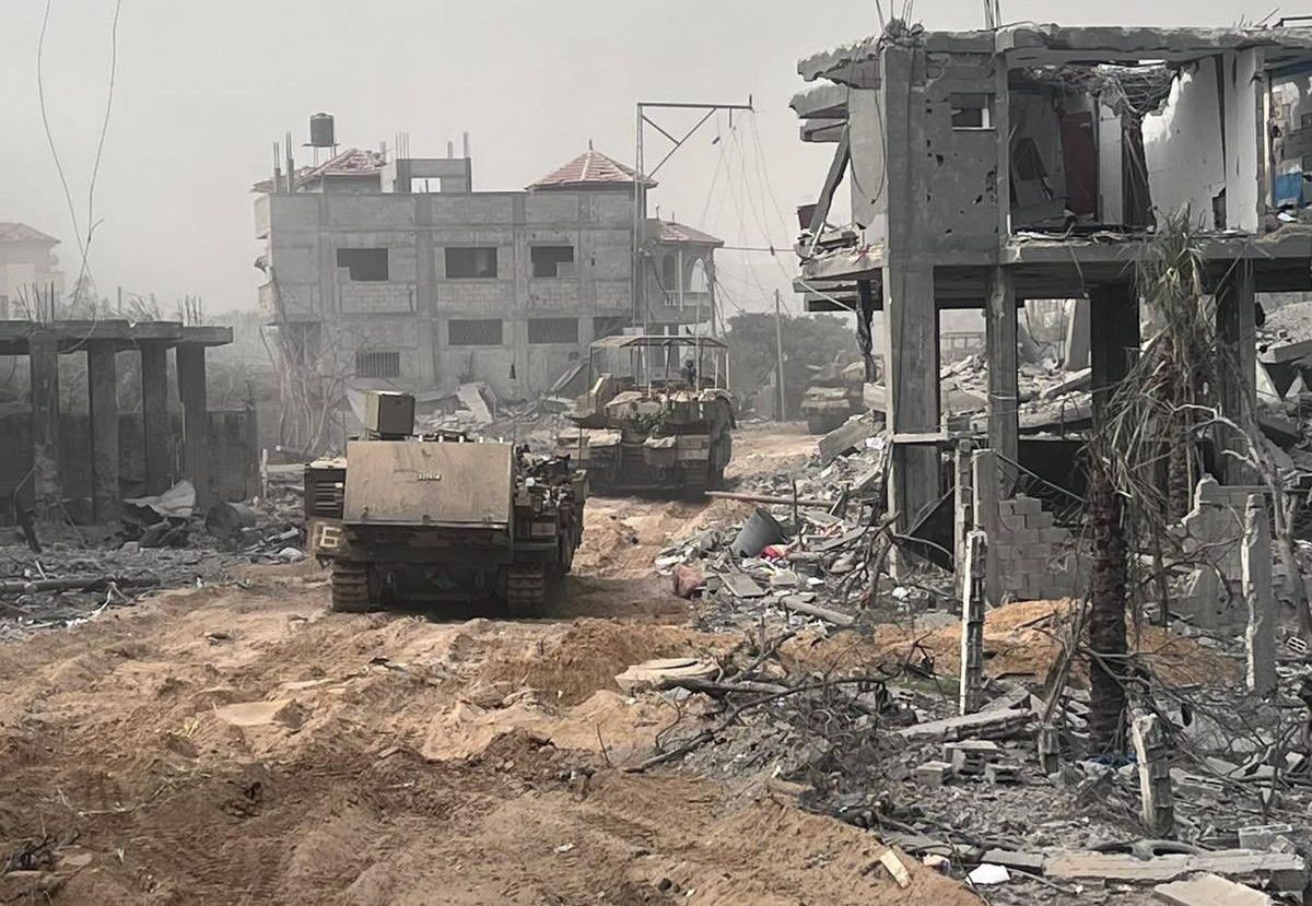 An Israeli Puma armored personnel carrier and Merkava Mk.4M tanks move among destroyed buildings in the northern Gaza Strip, September 1, 2023.